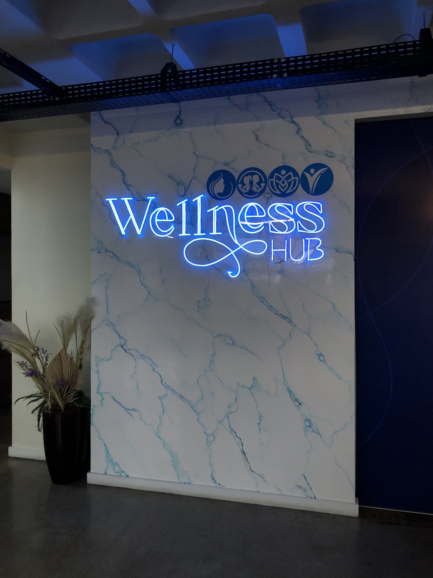 Letreiro neon Wellness Hub na recepção